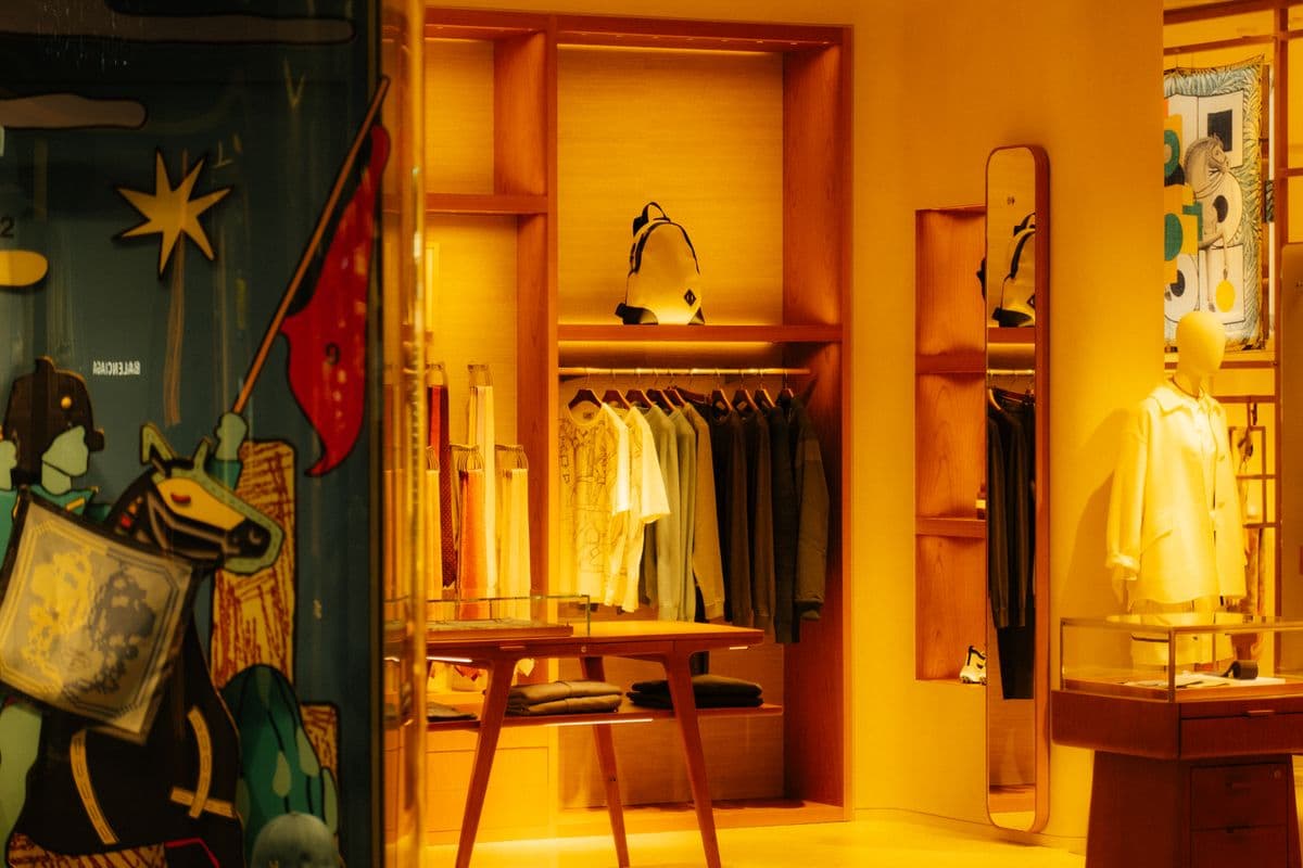 Shop interior with clothing rails under warm lighting
