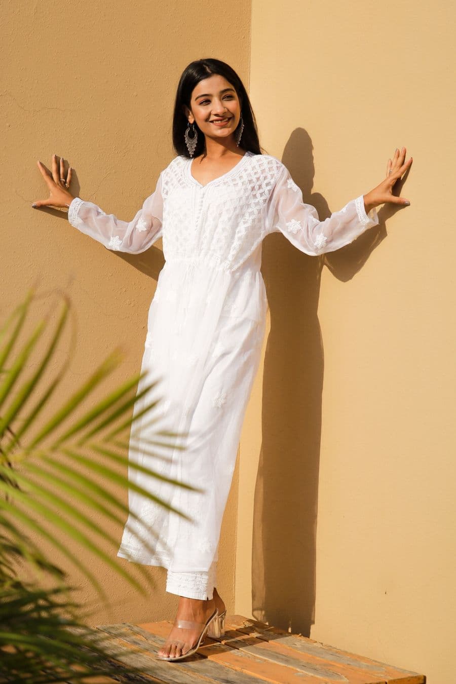 Woman in a white chikankari kurti standing outdoors